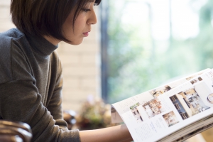 Women are reading a magazine in a cafe